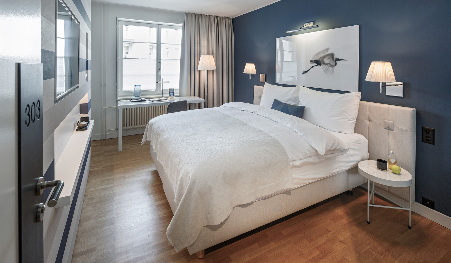Hotel Seehof Zürich Schweiz Doppelzimmer mit Flatscreen Fernseher Boxspring Betten Flos Lampen, Hay Stühlen, Marmor Nachttische, Arbeitsplatz mit internationalen Steckdosen und modernem Badezimmer.