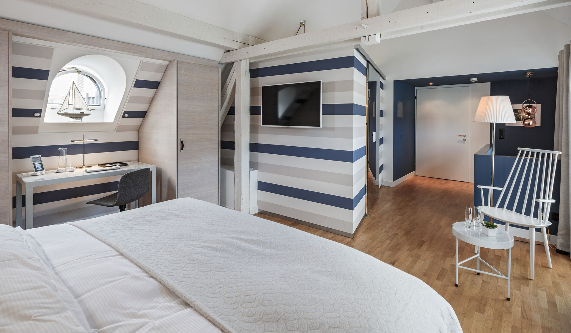 Hotel Seehof Zürich Schweiz Junior Suite mit Flatscreen Fernseher Boxspring Betten Flos Lampen, Hay Stühlen, Marmor Nachttische, Arbeitsplatz mit internationalen Steckdosen und modernem Badezimmer.